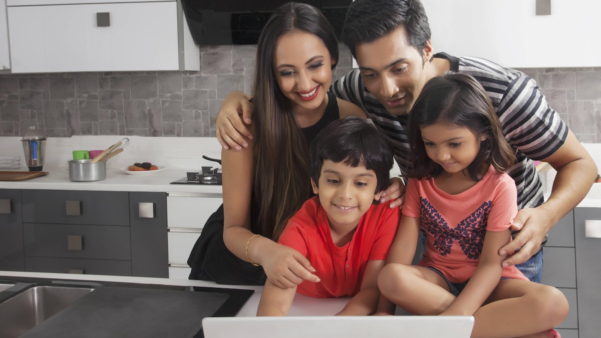 Family using laptop at kitchen table PUBLICATIONxNOTxINxIND SLHM11235DF