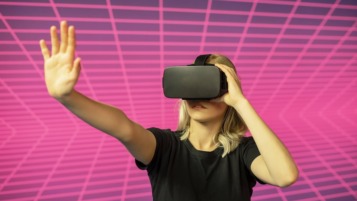 junge Frau mit VR-Brille steht vor Gitternetz *** young woman with VR glasses is standing in front of a grid